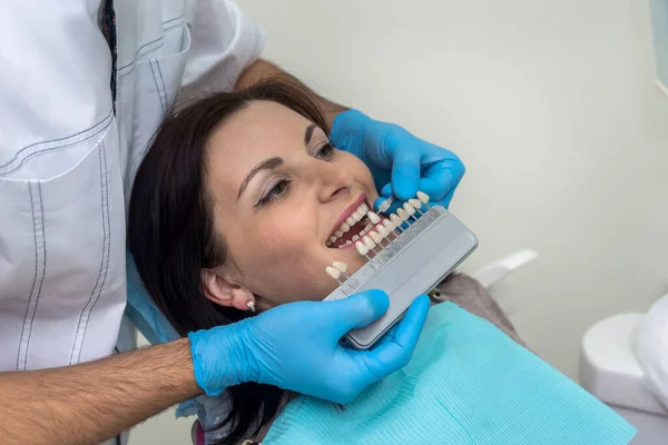 Doctor compare woman teeth with sampler in dentistry
