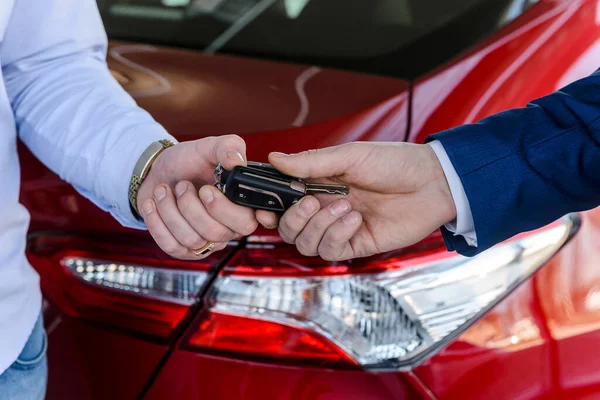 Männliche Hand Mit Autoschlüssel Gegen Neuwagen Verkaufsraum — Stockfoto