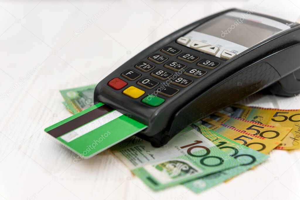 Banking terminal with credit card on australian dollar banknotes