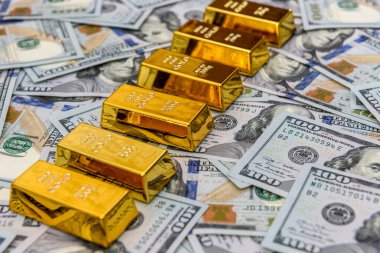 Altın külçeleri Amerikan doları banknotlarına yakın.