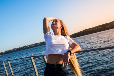 Gün doğumunda gölde poz veren genç bir kadın.