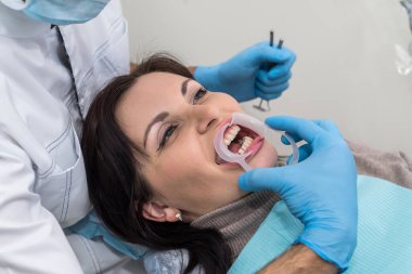 Dişçilerin elleri enstrümanlarla ve hasta yüzü ile yakın çekim