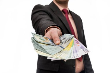 Erkek eli yığınla dolar ve avro banknotları sunuyor