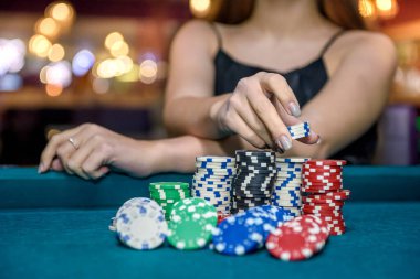 Yığından poker çiplerini alan kadın.