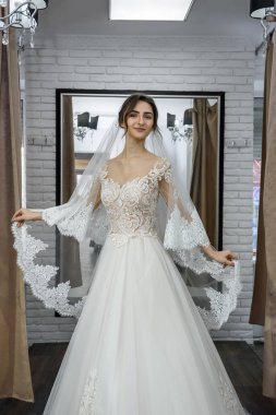 Salonda gelinlik giymiş genç gelinin portresi.