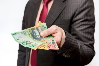 Erkek el, beyaza izole edilmiş Avustralya doları banknotları sunuyor.