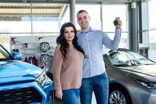 Yeni arabanın anahtarlarıyla poz veren mutlu çift.