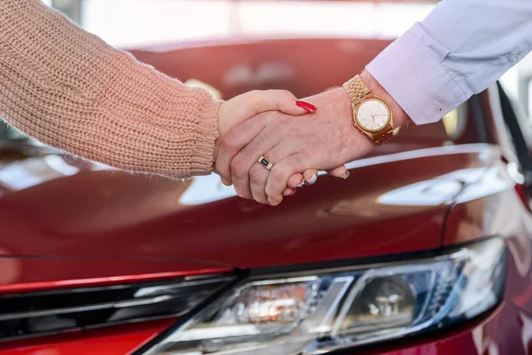 Human handshakes close up on car background