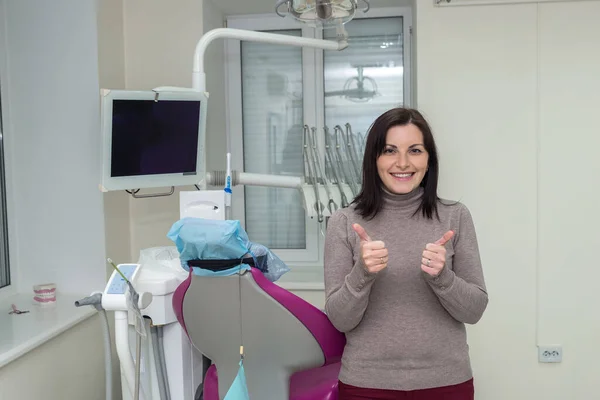 Smiling woman patient in dentistry after stomatological procedures