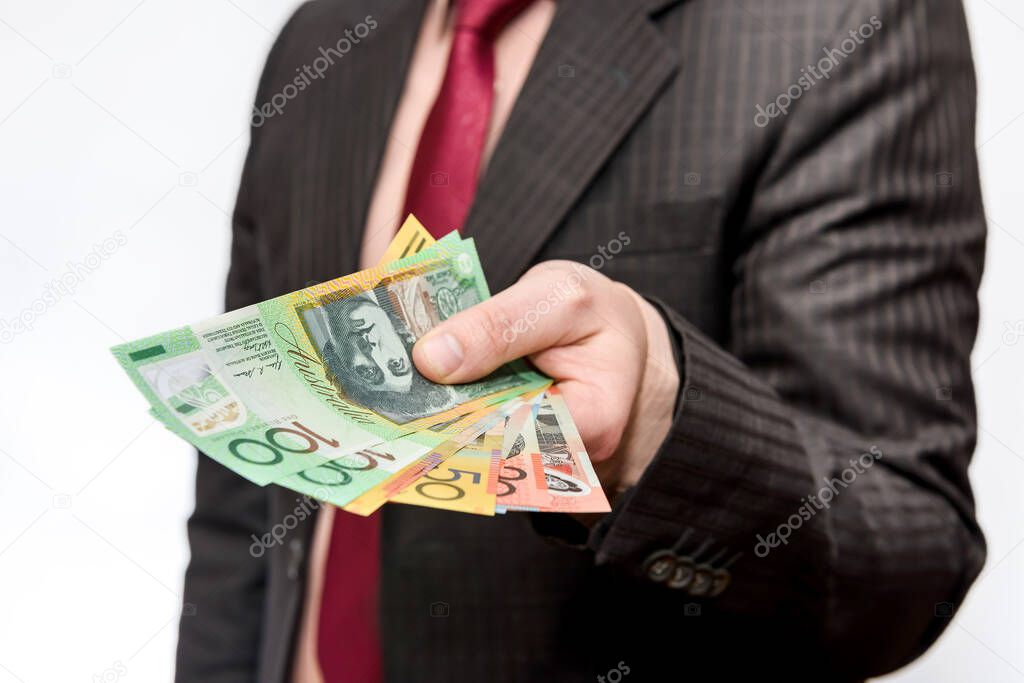 Male hand offering australian dollar banknotes isolated on white