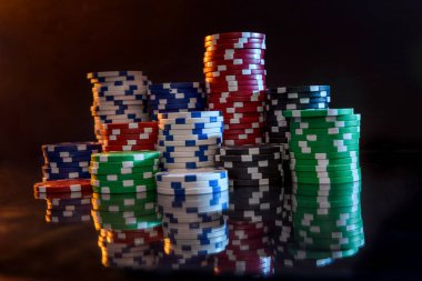 Yansıyan yüzey üzerindeki renkli poker çipleri