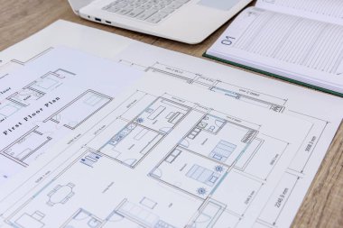 Plan, dizüstü bilgisayar, ahşap masadaki defter.