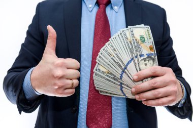 Takım elbiseli adam dolar banknotlarını tutuyor.