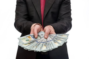 Takım elbiseli bir adam dolar banknotları tutuyor.
