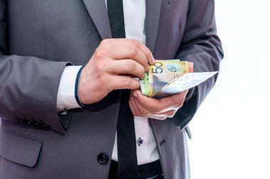 Takım elbiseli adam renkli Avustralya doları sayıyor.