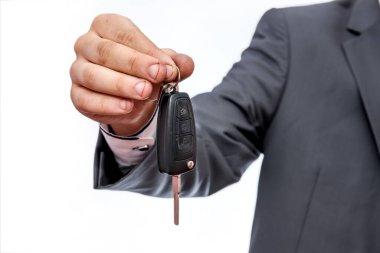 Araba anahtarı olan bir erkek. Beyazlara yakın.