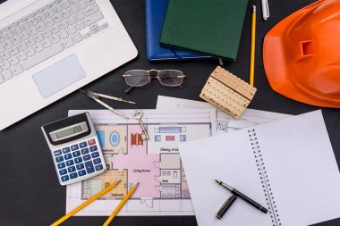 Dizüstü bilgisayarı ve ev planı olan bir mühendis işyeri. 