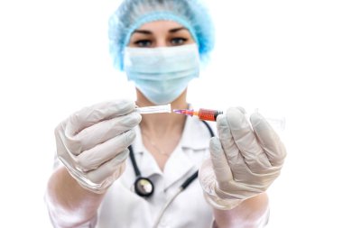 Beyaz şırıngalı, tıp üniformalı genç bir kadın.