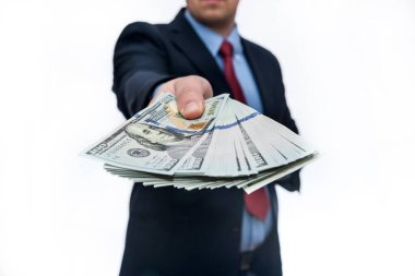 Beyaz arka planda dolar banknotları gösteren takım elbiseli bir adam.