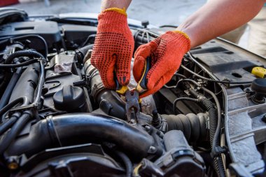 Eldivenler ve araba motoru yakın.