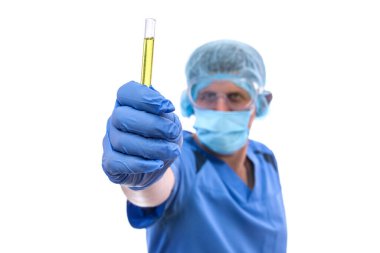 Kimyager çalışıyor. Koruyucu üniformalı bir adam test tüplerini beyazın üzerinde tutuyor.