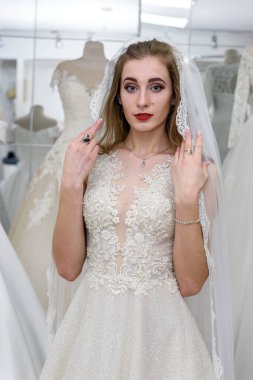 Gelinlikli güzel gelin butikte duruyor.