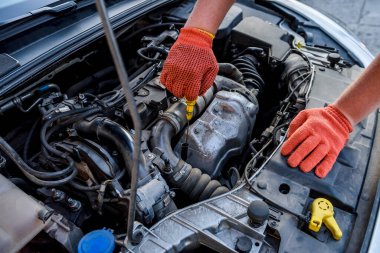 Elleri koruyucu eldivenlerle arabanın motorunu kapat. Araba tamiri kavramı