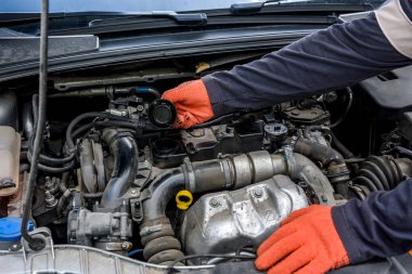 Elleri koruyucu eldivenlerle arabanın motorunu kapat. Araba tamiri kavramı