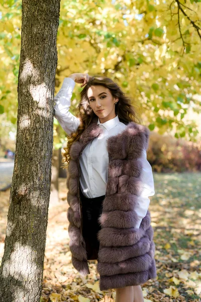 秋天公园里穿着时髦皮衣走路的女人 — 图库照片