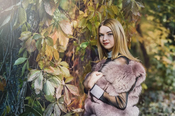 时尚女人 在秋天的公园里 穿着毛皮外套 长着树木和常春藤的微笑女孩 — 图库照片