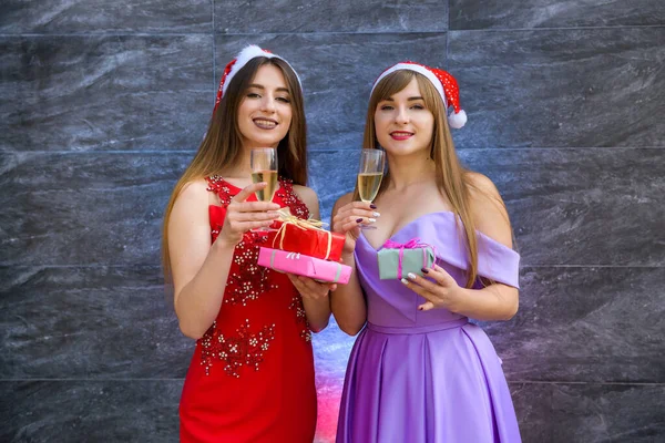 Dwie Szczęśliwe Uśmiechnięte Dziewczyny Świątecznych Kapeluszach Tosty Kieliszkami Szampana Nowy — Zdjęcie stockowe