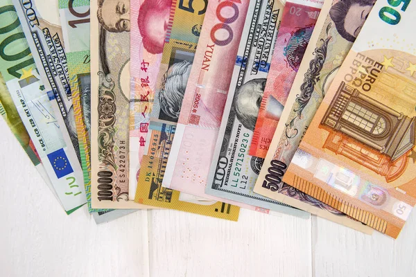 Kolorowe Międzynarodowe Banknoty Wentylatorze Jasnym Drewnianym Stole — Zdjęcie stockowe