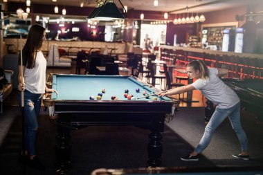 Pub 'da bilardo oynayan gülümseyen arkadaşlar