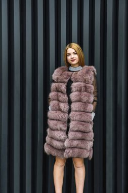 Şehir caddesinde poz veren kürklü şık bir kadın. Moda konsepti