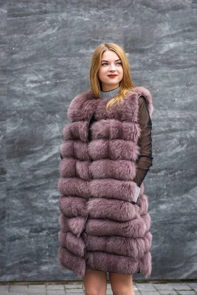 穿着毛皮外套的时髦女人站在城市街道上摆姿势 时尚概念 — 图库照片