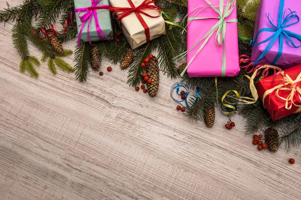 Karácsonyi Ajándék Koncepció Fenyőágak Tobozokkal Színes Ajándékdobozokkal Asztalon — Stock Fotó