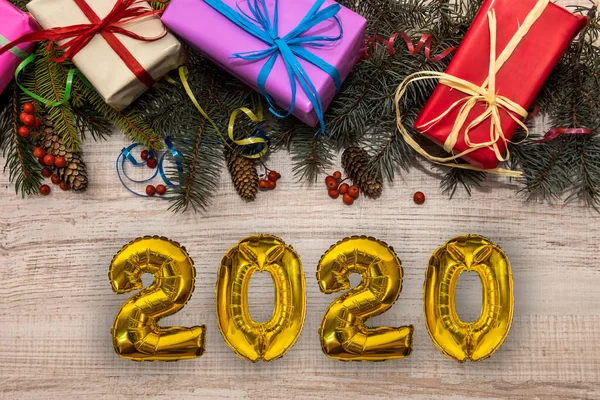Renkli hediye kutuları ve köknar dallarıyla 2020 altın hava balonları. Noel ve Yeni Yıl Kutlamaları