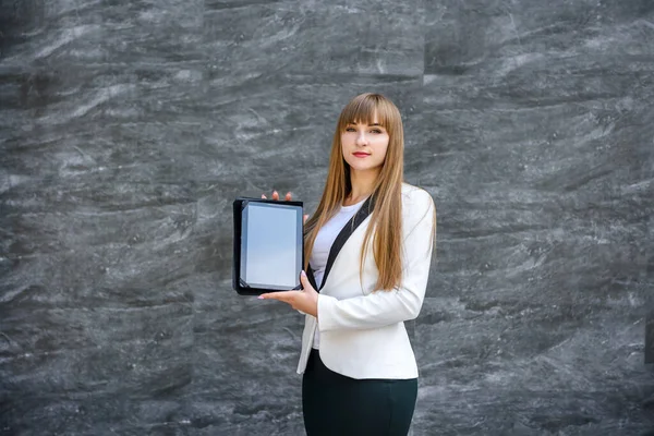 Portrait of young business woman with tablet over grey background