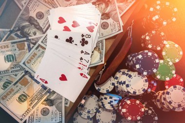 Poker kombinasyonu - kart fişleri ve para siyah masanın üzerinde.