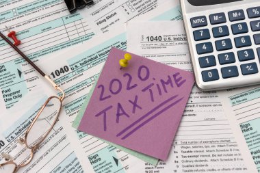 2020 Tax Company. Colorful stickers with reminder at 1040 tax form close up clipart