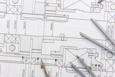 Kağıt üzerinde teknik çizimler ve çalışma araçları var. iş yeri