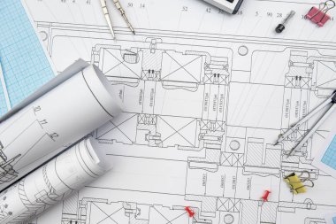 Kağıt üzerinde teknik çizimler ve çalışma araçları var. iş yeri