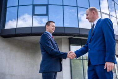 Büyük bina açılmadan önce iş ortakları el sıkışıyor.