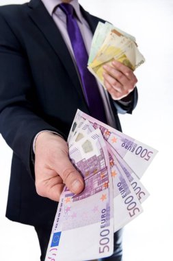 Takım elbiseli adam beyaza izole edilmiş avro banknotları teklif ediyor.