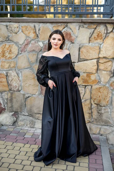 レンガの背景に黒いドレスのファッション笑顔の女性 ファッション — ストック写真