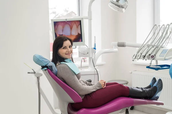 Woman sitting in dentist\'s chair and smiling