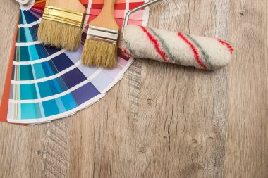 Renkli palet rehberi ve tahta üzerinde boya fırçası silindiri