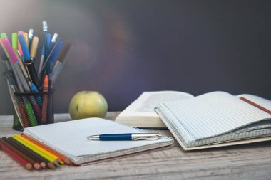 Yazı tahtasına karşı öğretmen masasında boş not defteri. eğitim kavramı.