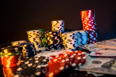 Poker fişleri ve oyun kartları siyah masada.