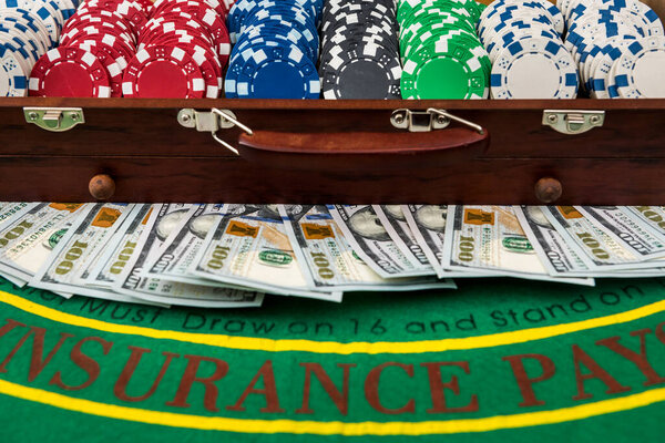 Концепция игры. Красочные фишки для покера с американскими долларами в деревянной коробке на зеленом игровом столе
.